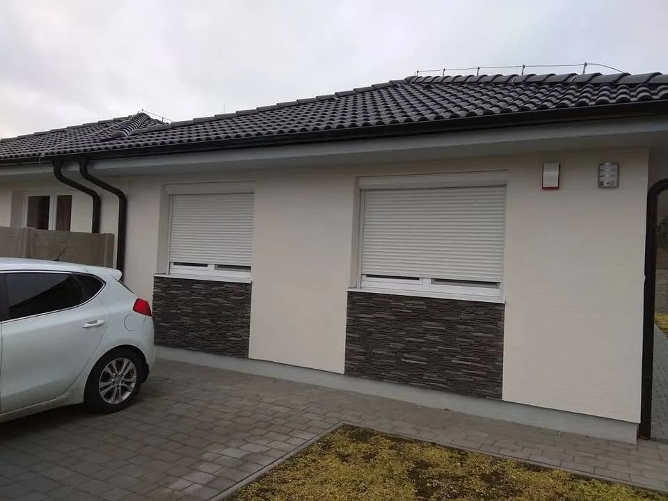 Fehér kültéri redőnyök egy földszintes házon